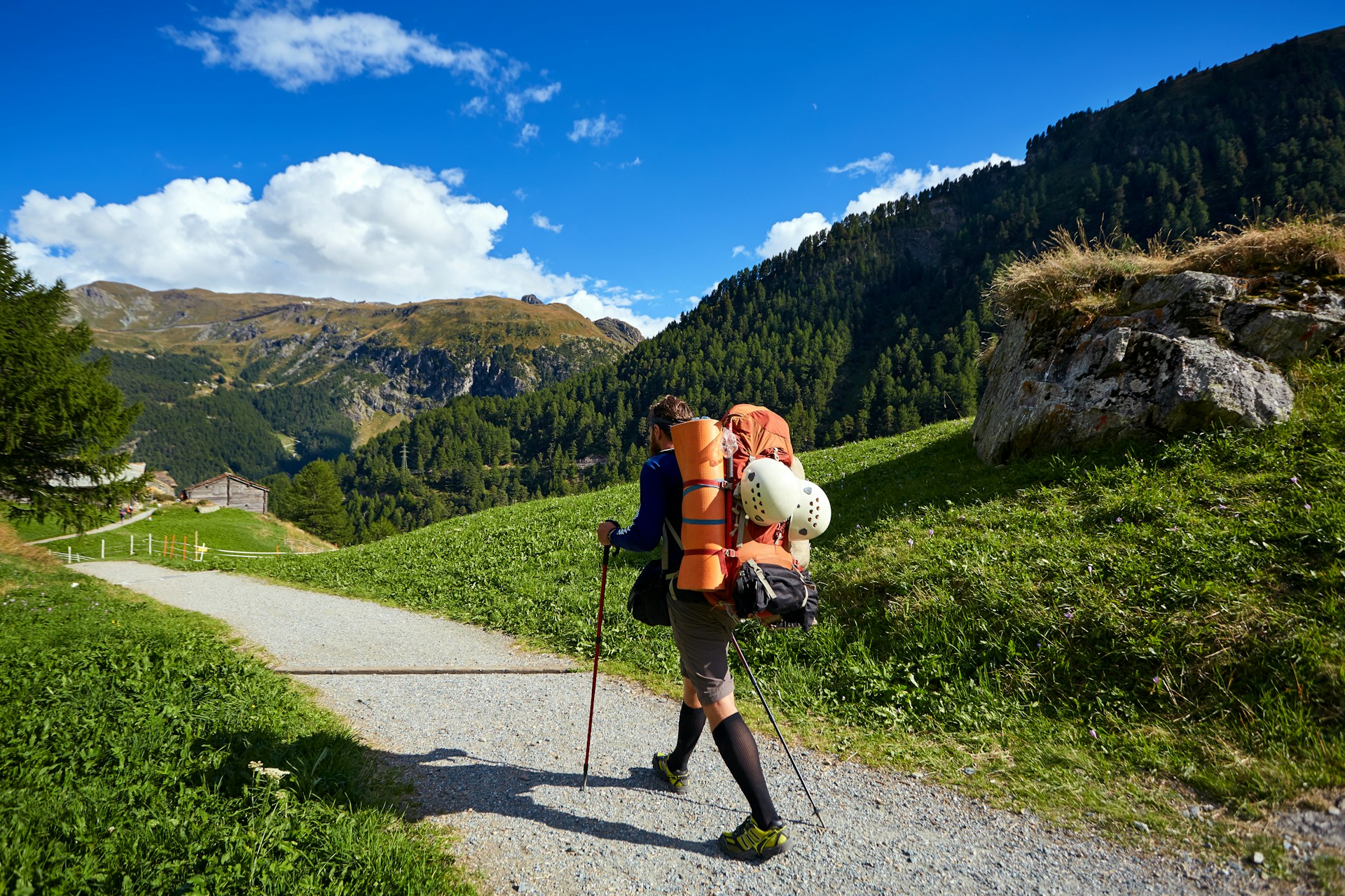 Solo traveler walking along a mountain trail, representing handling change, adaptability, and personal growth.